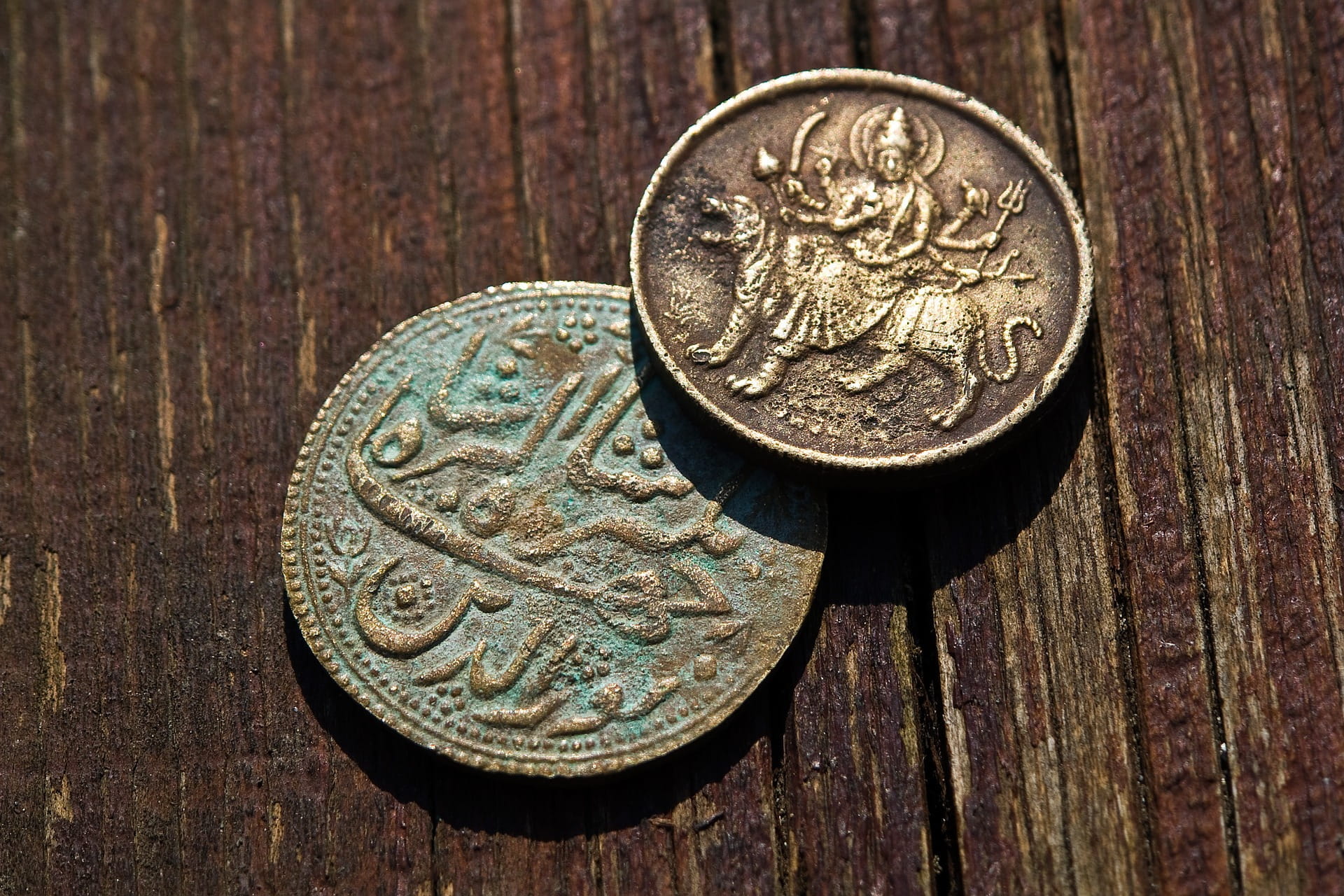 Alte Münzen auf einem Holztisch.