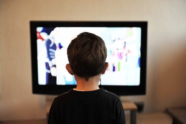Ein Kind sitzt vor dem Fernseher.