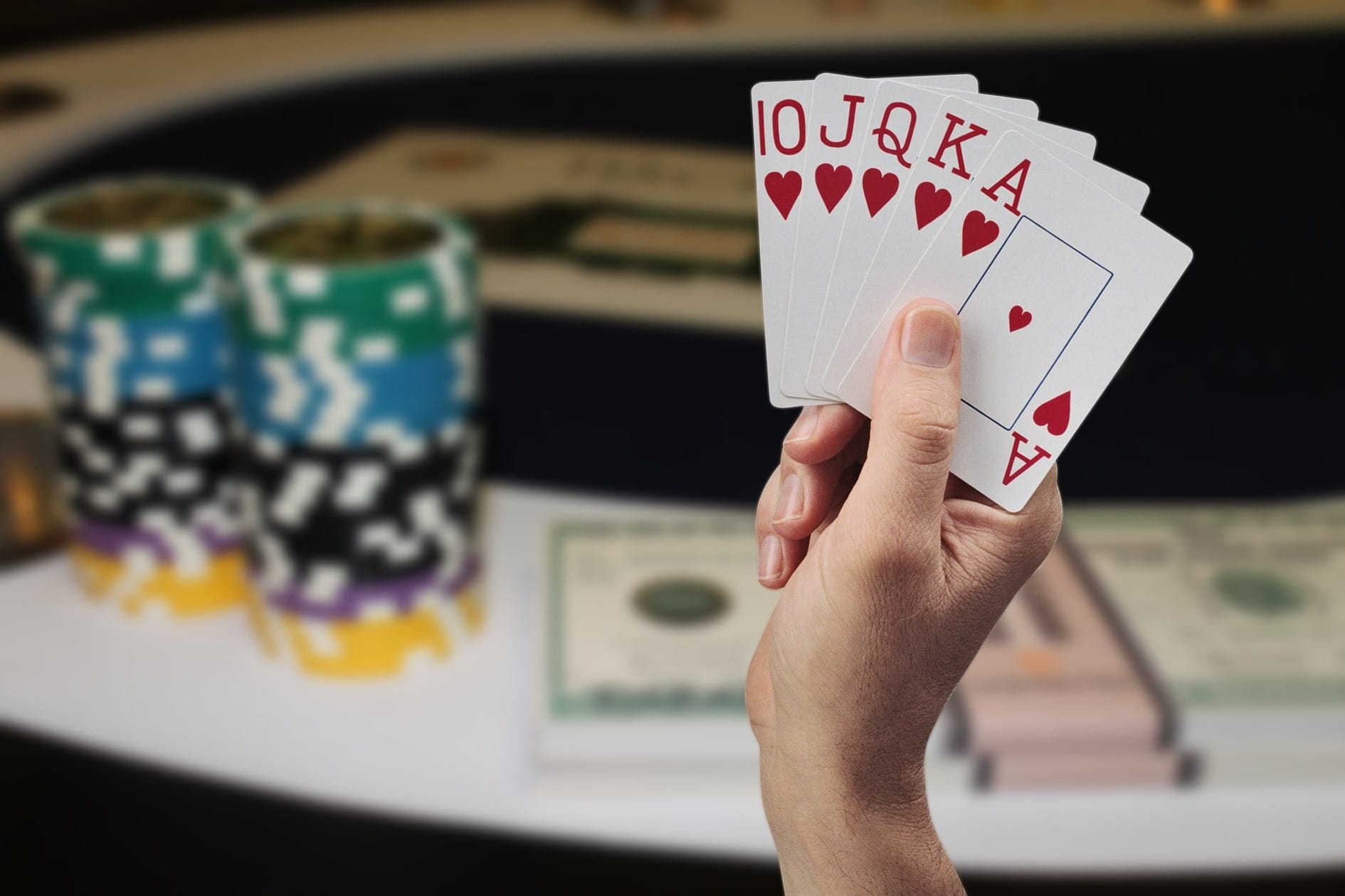 Pokerkarten, Spielchips und Geldbündel.