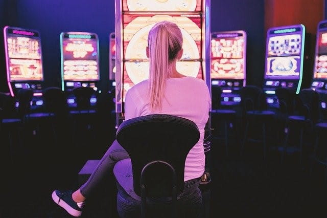 Eine Frau spielt an einem Automaten in einer Spielhalle.