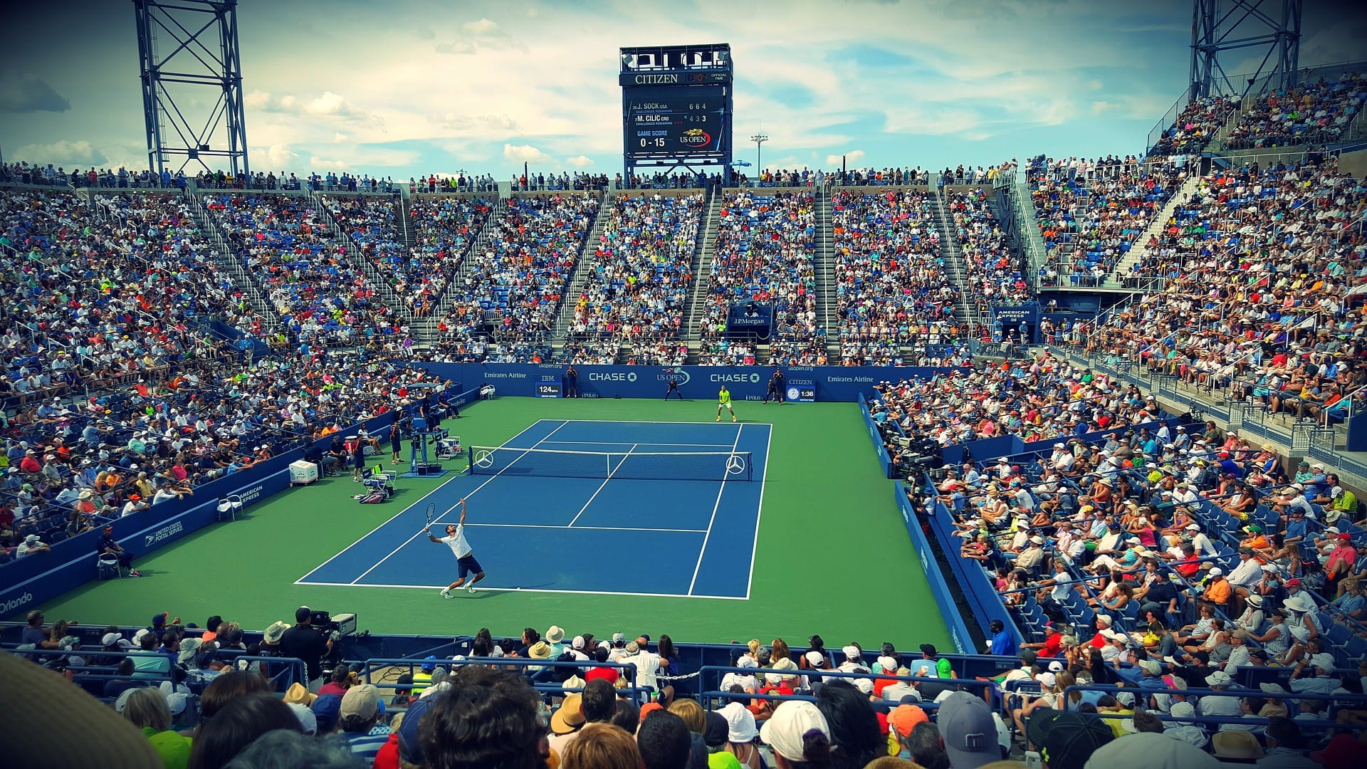 Ein vollbesetztes Stadion eines Tennisturniers – zwei Spieler sind gerade beim Spielen.