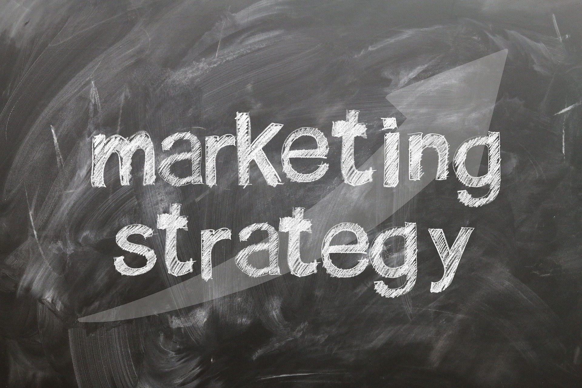Auf einer Kreidetafel stehen die Worte Marketing Strategy.