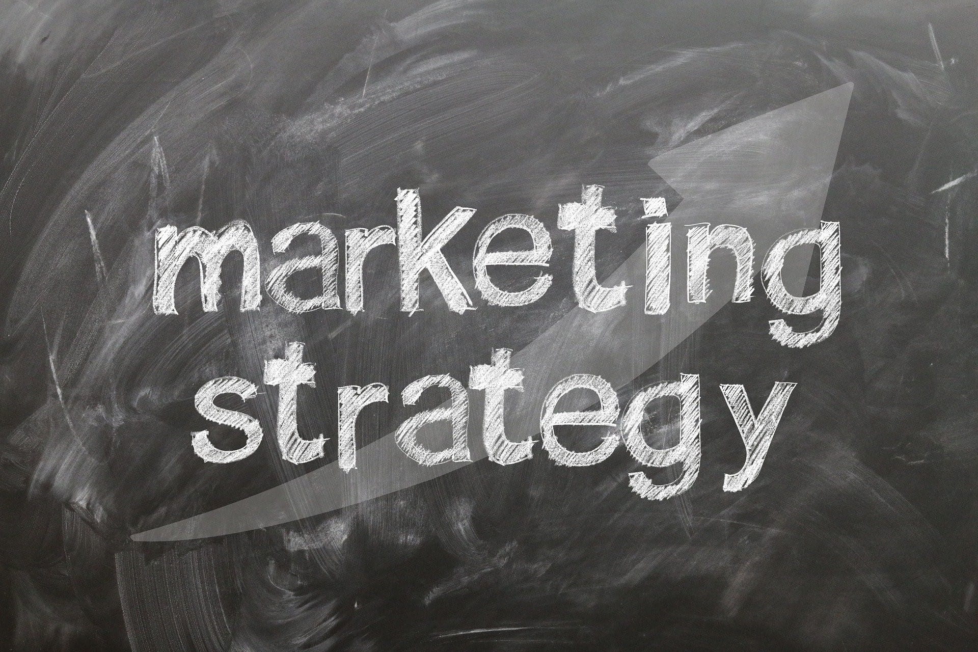 Auf einer Kreidetafel stehen die Worte Marketing Strategy.