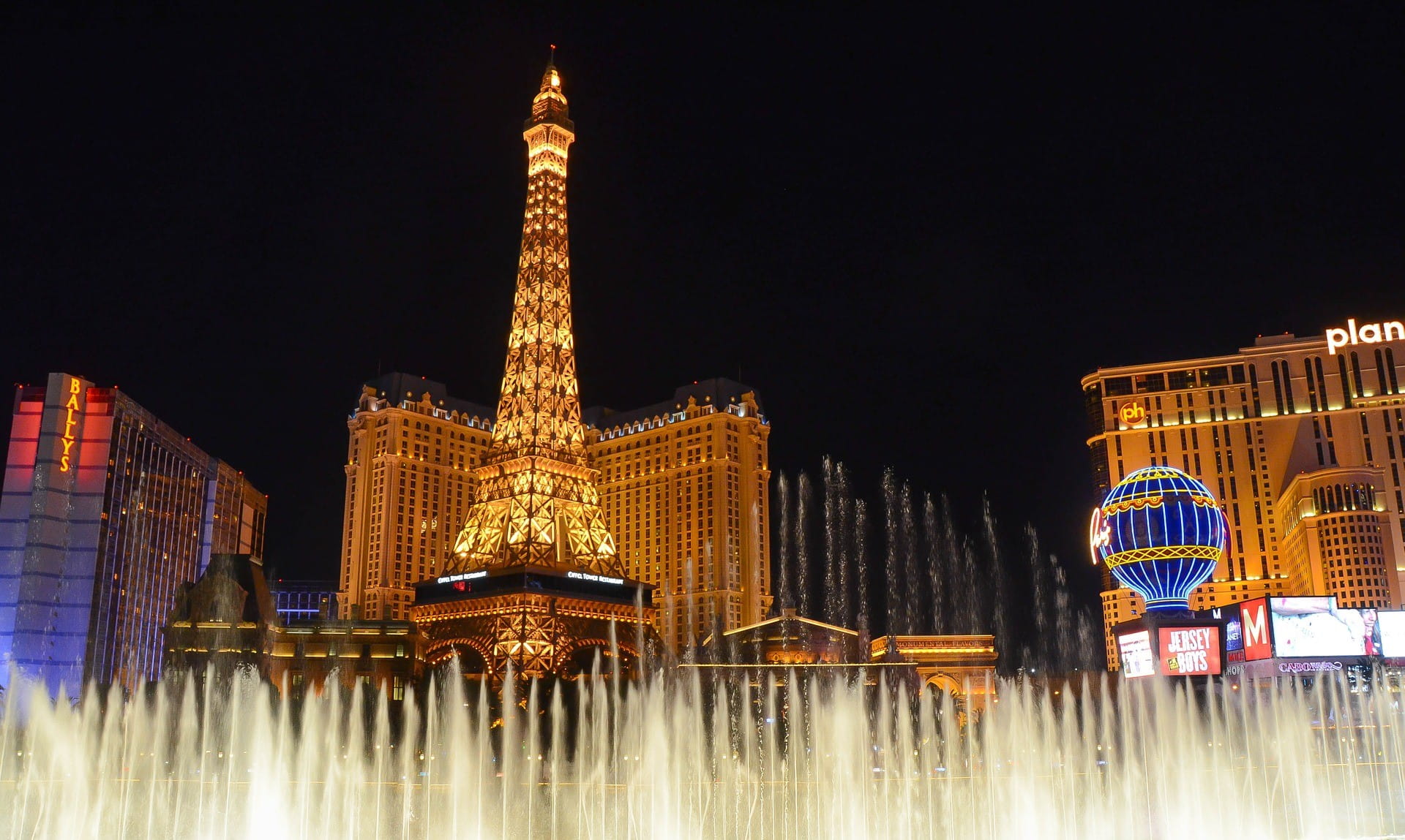 Las Vegas di malam hari - ada air mancur menyelam di latar depan dan kasino di latar belakang.