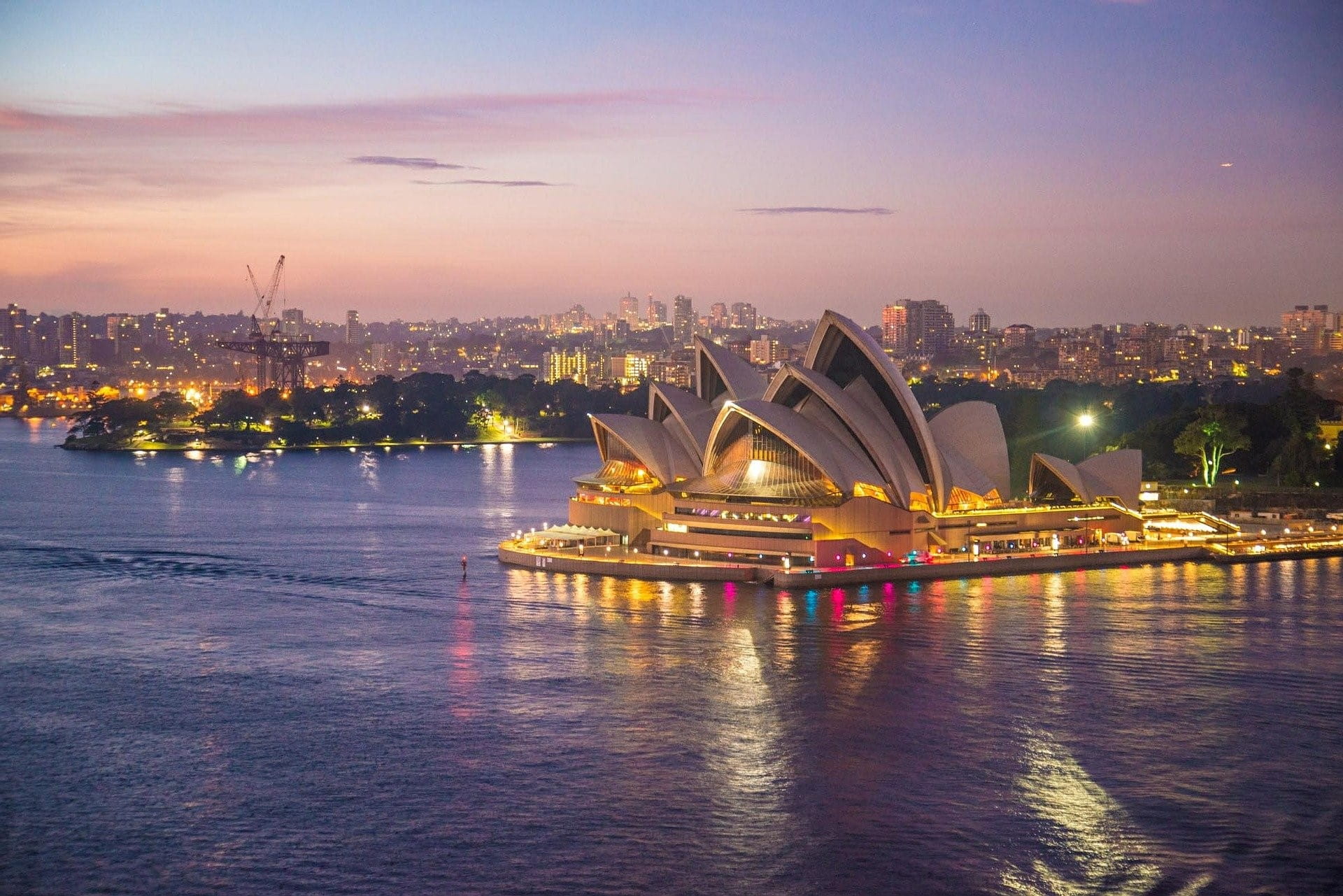 Blick auf Sydney bei Nacht – im Vordergrund ist das berühmte Opernhaus zu sehen.