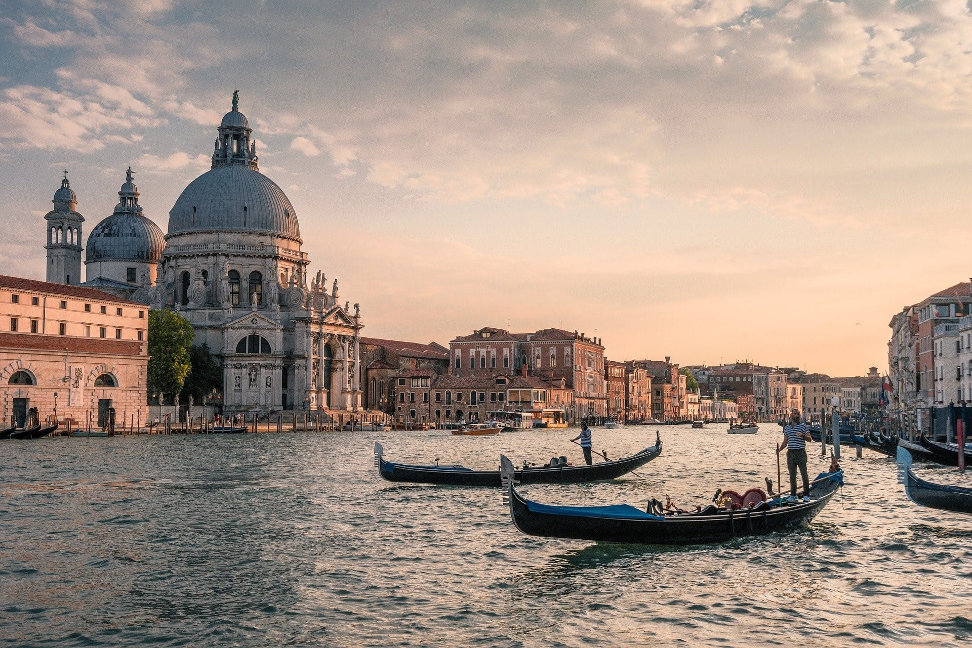 Zwei Gondeln fahren durch Venedig – links ist die Kathedrale zu sehen.