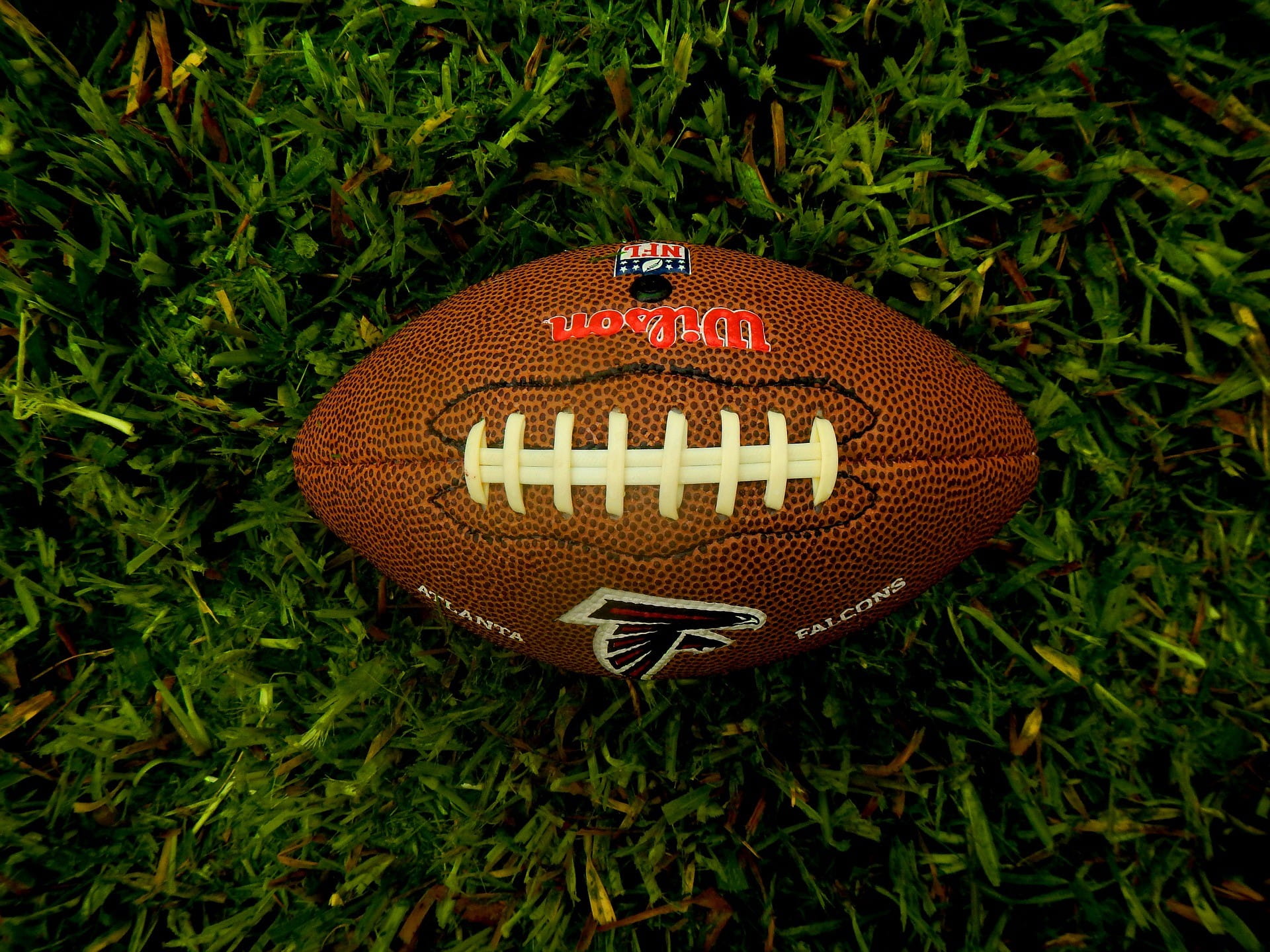 Ein brauner Football der Atlanta Falcons liegt auf dem Rasen.