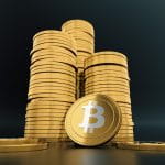 Auf einem Tisch stehen drei Stapel mit virtuellen Bitcoin-Münzen.