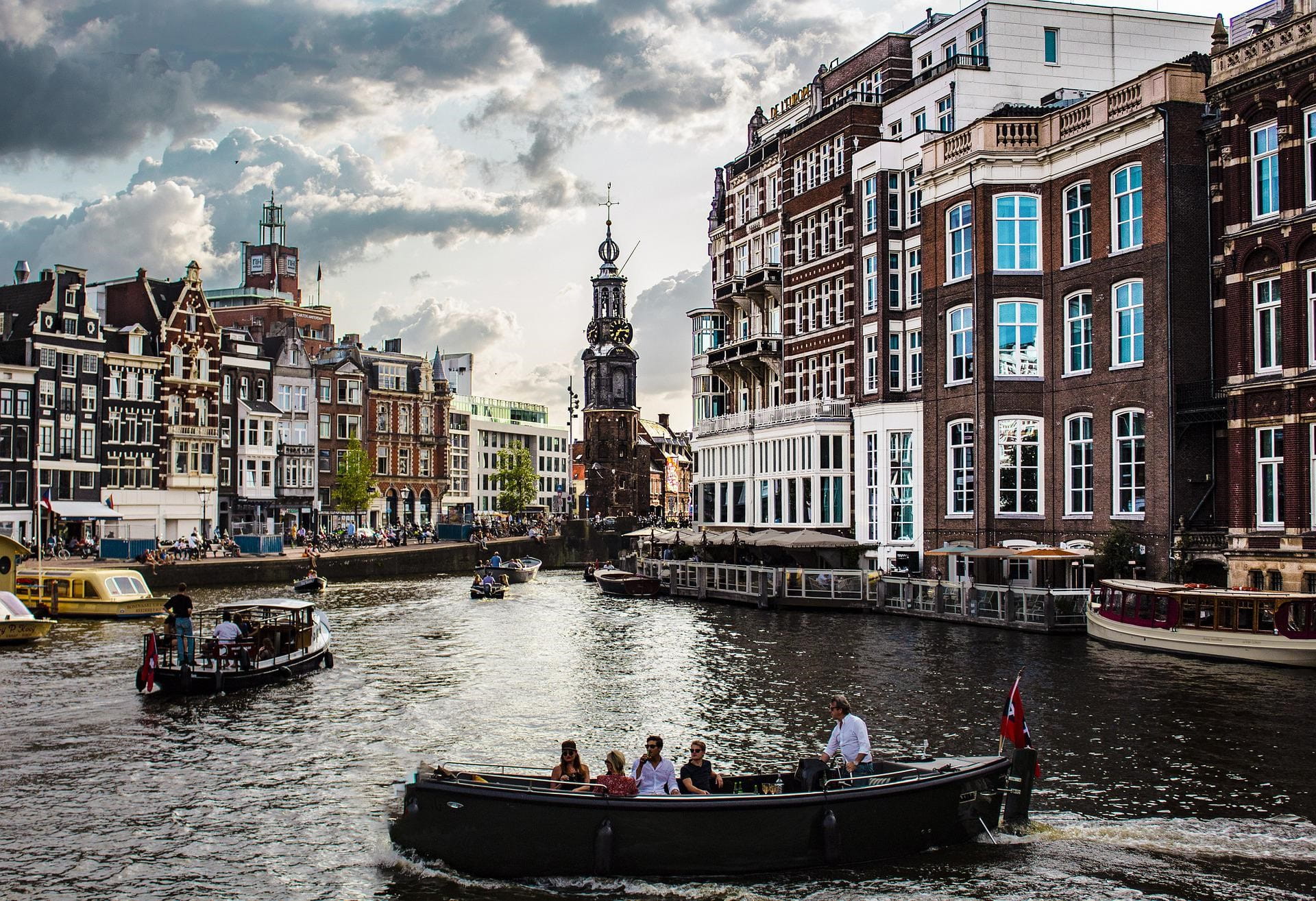 Durch die niederländische Hauptstadt Amsterdam fließt ein Fluss, der von vielen Booten genutzt wird.
