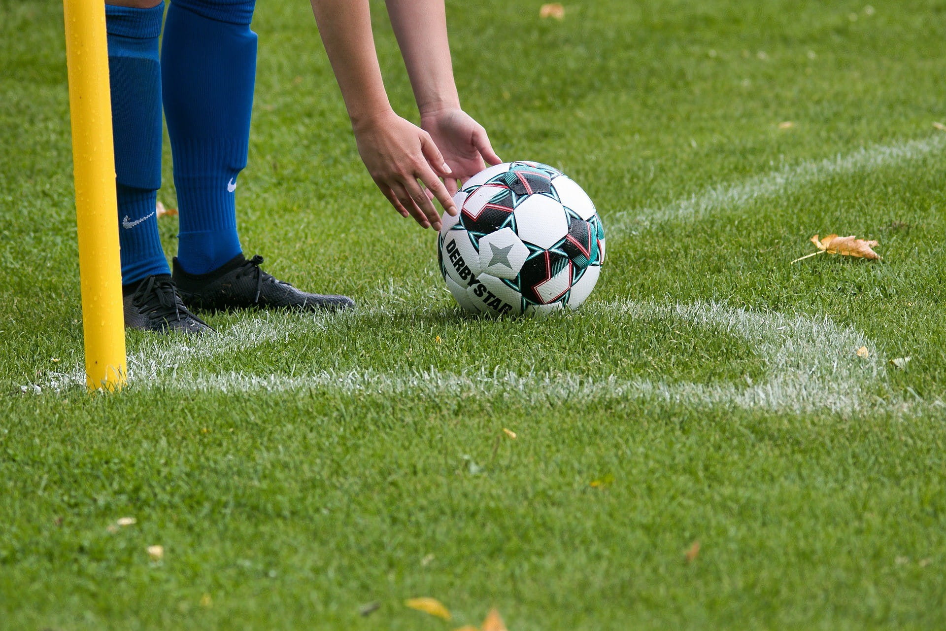 Ein Fußballspieler setzt den Fußball wegen Eckball auf die richtige Position.