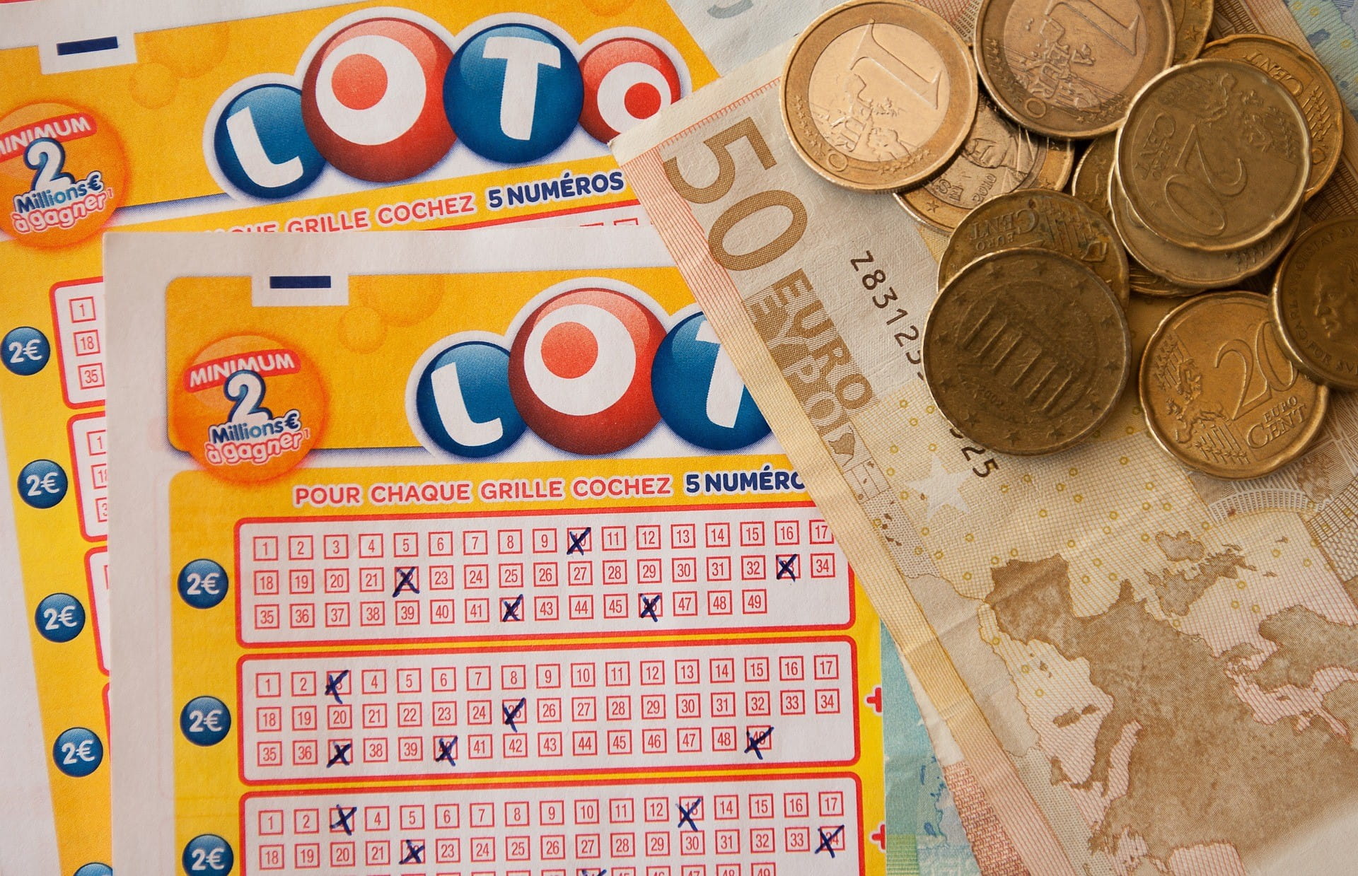 Ada banyak koin dan uang kertas 50 euro pada dua tiket lotere.