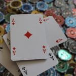 Auf sehr vielen Spielchips liegen vier sich überkreuzende Pokerkarten.