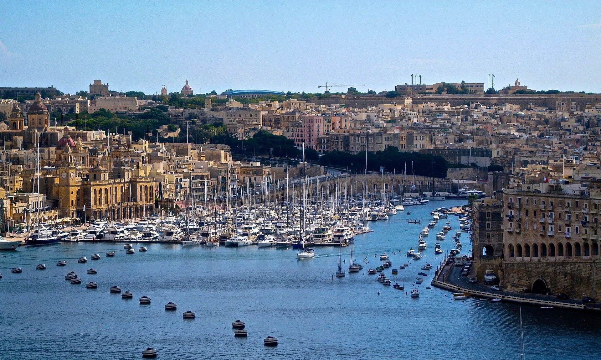 Eine Küstenstadt auf Malta mit einem großen Yachthafen.