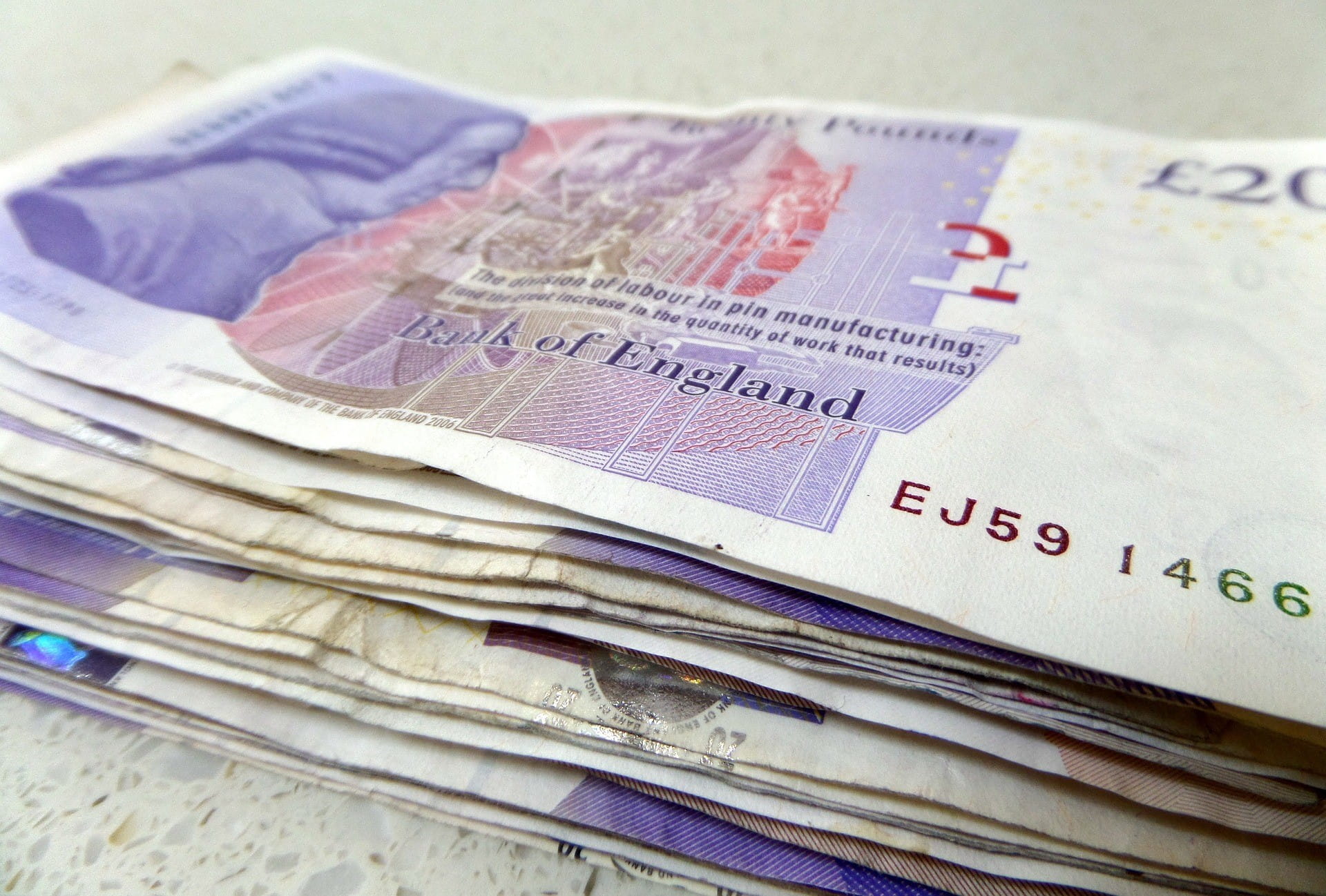 Beberapa uang kertas Inggris ditumpuk satu sama lain.