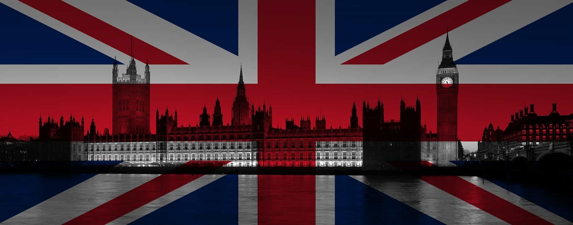 Ein schwarzes Foto des britischen Parlaments und davor die britische Flagge.