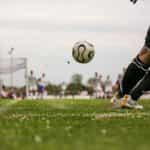 Während eines Spiels fliegt der Fußball direkt auf den Torwart zu, der sich für die Abwehr in Position bringt.