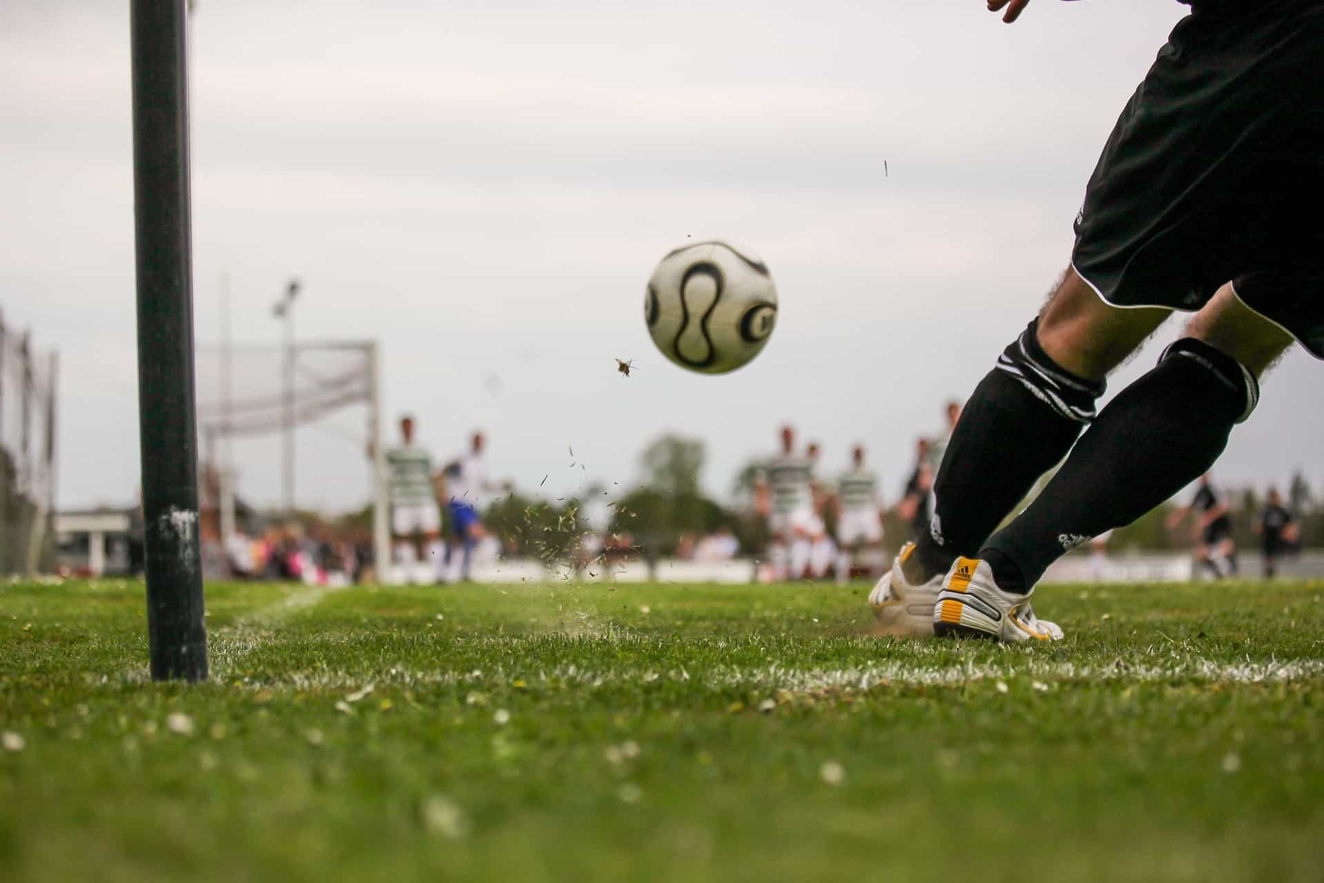Während eines Spiels fliegt der Fußball direkt auf den Torwart zu, der sich für die Abwehr in Position bringt.