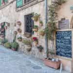 Eine für Mallorca typische Hausfassade mit aufgehängten Blumentöpfen.