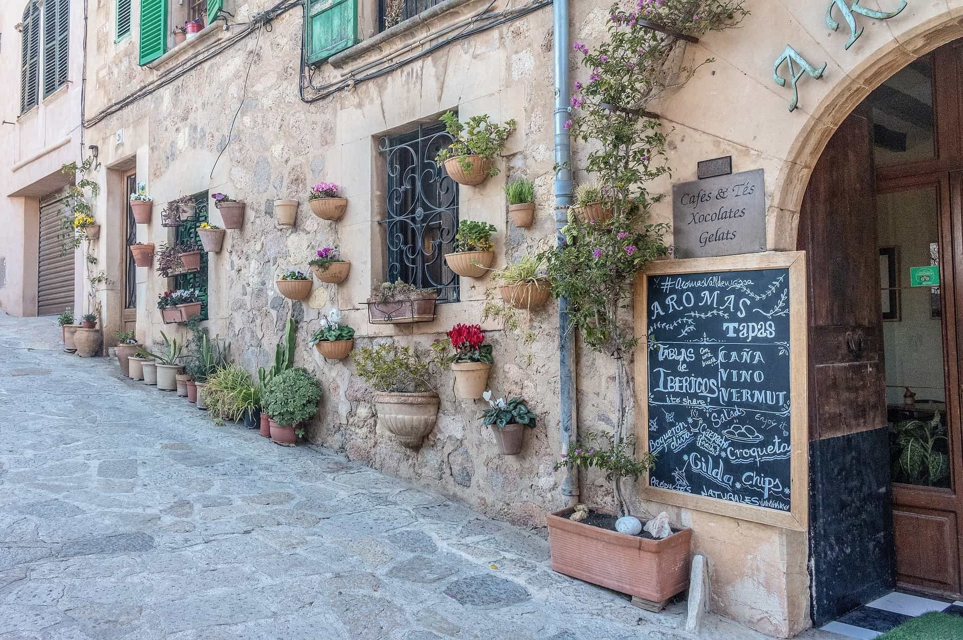 Eine für Mallorca typische Hausfassade mit aufgehängten Blumentöpfen.