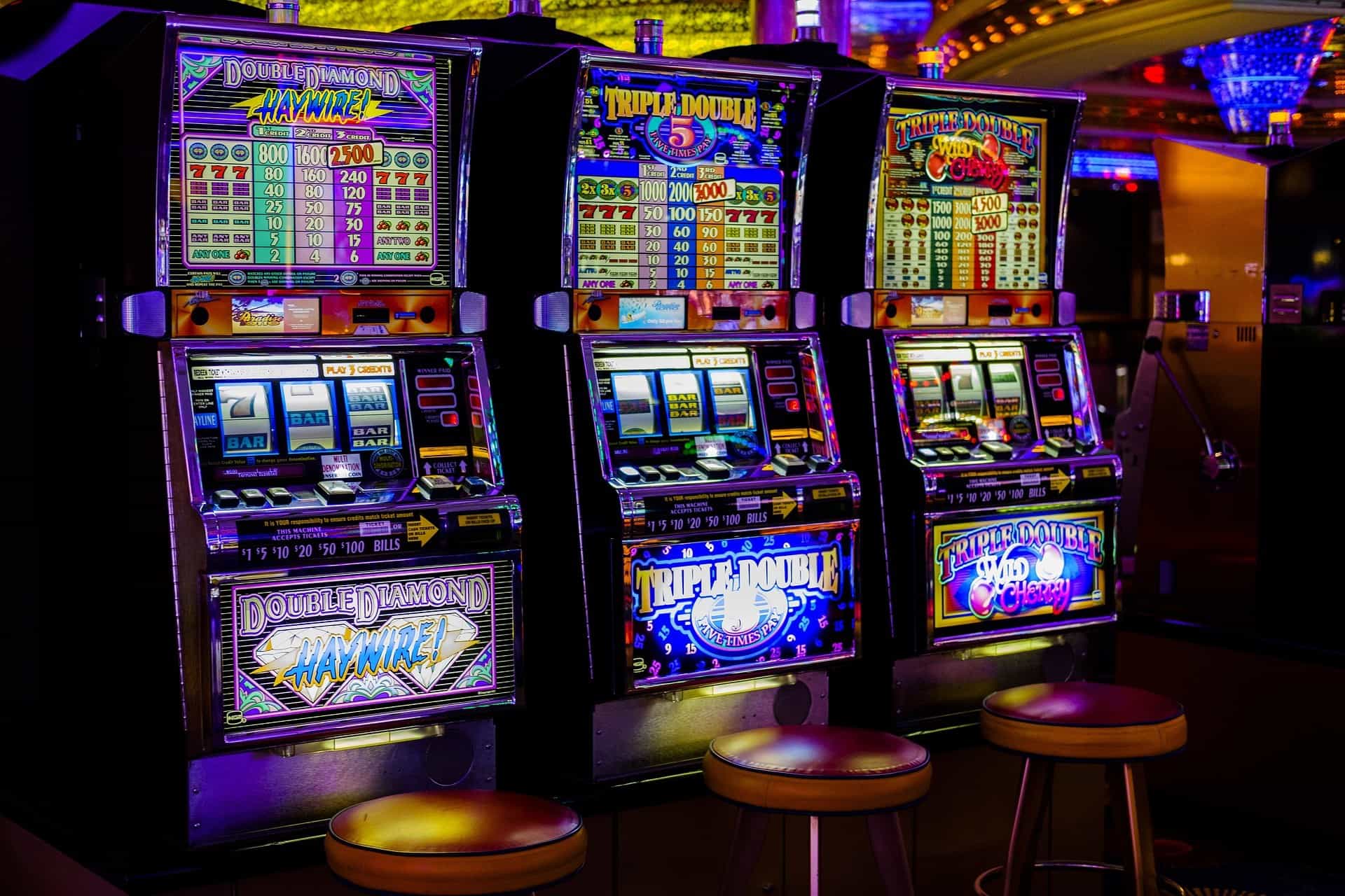 In einem Casino stehen drei Spielautomaten nebeneinander.
