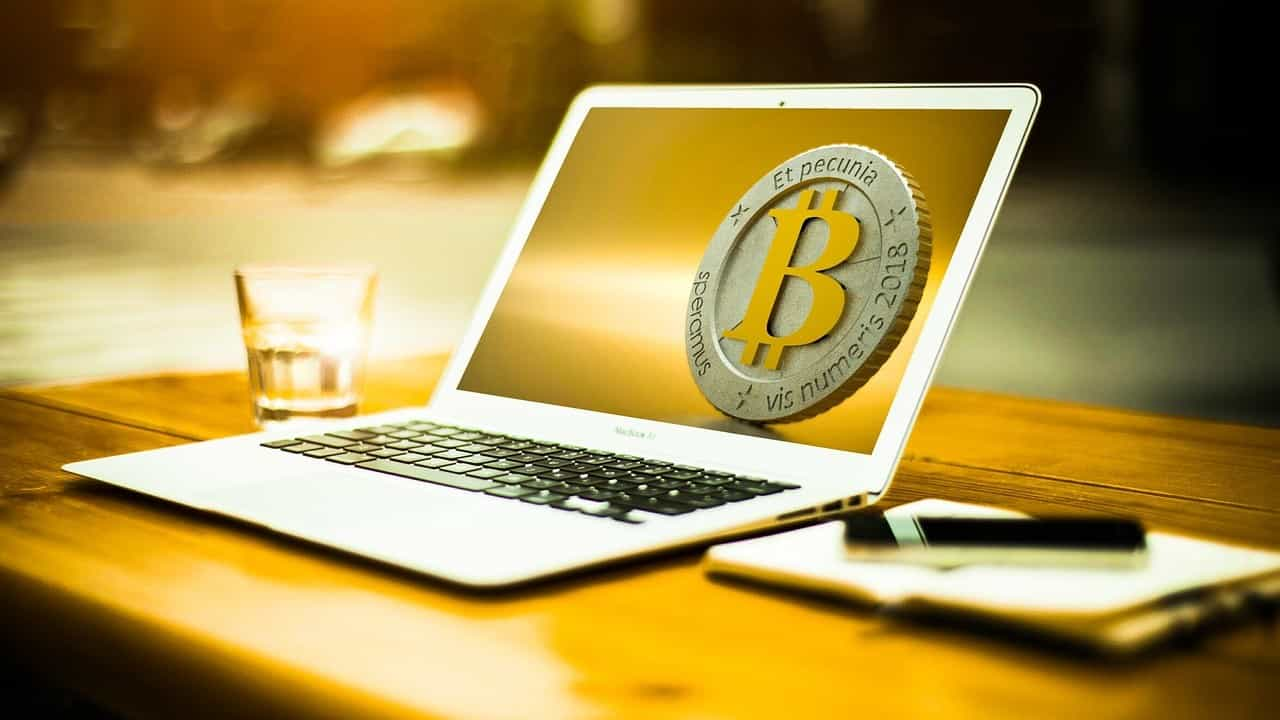 Auf dem Bildschirm eines Laptops ist ein Bitcoin abgebildet.