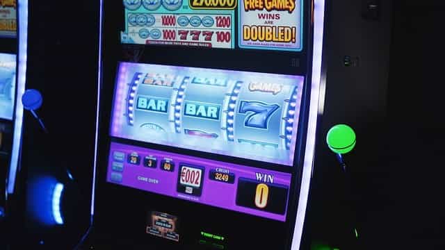 Ein typischer Glücksspielautomat mit drei Walzen und klassischen Glücksspielsymbolen.