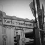 Ein Ausschnitt des Kurfürstendamms in Berlin, inklusive Straßenschild.