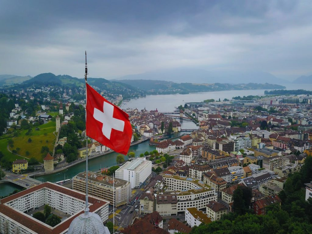 Schweizer Flagge vor einem Stadtpanorama