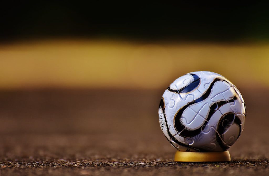 Fußball auf einem kleinen Sockel auf dem Boden stehend.